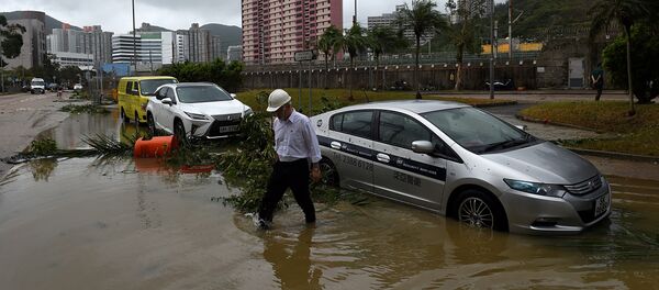 A man wades through floodwaters away from his car after heavy rains brought on by Typhoon Hato in Hong Kong on August 23, 2017 - Sputnik International