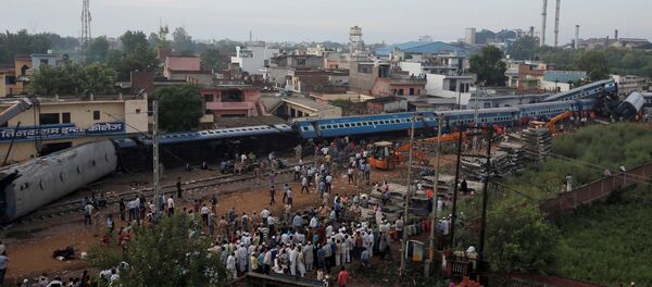 Rescue workers and onlookers stand next to derailed coaches of a passenger train at the site of an accident in Khatauli, in the northern state of Uttar Pradesh, India August 20, 2017 - Sputnik International