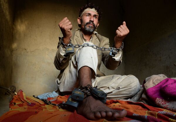 In this photograph taken on April 25, 2017, a mentally ill Afghan patient sits chained to a wall at the Mia Ali Baba holy shrine in the village of Samar Khel on the outskirts of Jalalabad - Sputnik International