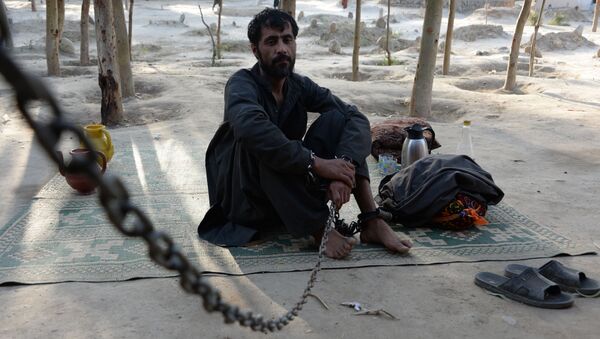 In this photograph taken on May 2, 2017, a mentally ill Afghan patient sits as he chained at the Mia Ali Baba holy shrine in the village of Samar Khel on the outskirts of Jalalabad - Sputnik International