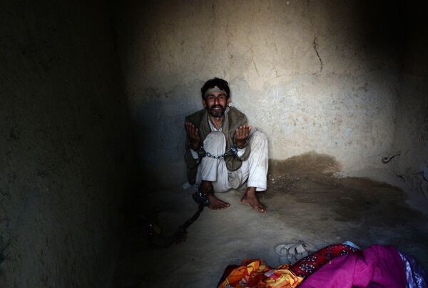 In this photograph taken on April 27, 2017, a mentally ill Afghan patient prays as he is chained at the Mia Ali Baba holy shrine in the village of Samar Khel on the outskirts of Jalalabad - Sputnik International