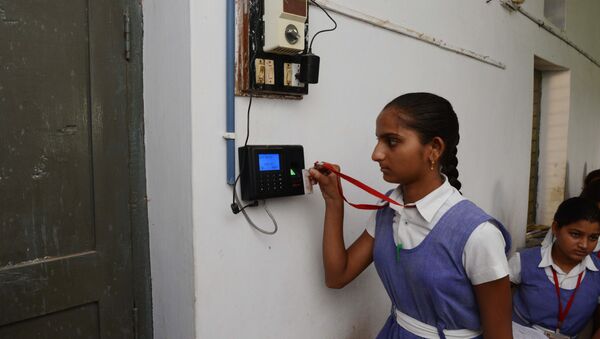 An Indian schoolgirl uses an electronic ID card to mark her attendance at a school in the first Indian 'Digital Village' in Akodara, some 90 kms from Ahmedabad, on 8 July 2015. - Sputnik International