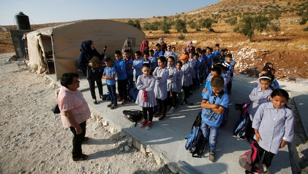 Palestinian schoolchildren queue outside a tent where they attend lessons after Israeli troops confiscated caravans used as school classrooms, due to the lack of an Israeli-issued construction permit, in the West Bank village of Jubbet Al Dhib, near Bethlehem August 24, 2017 - Sputnik International