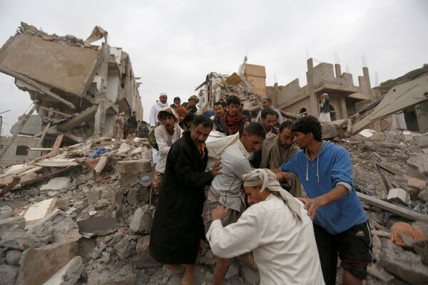 People carry the body of a woman they recovered from under the rubble of a house destroyed by a Saudi-led air strike in Sanaa, Yemen August 25, 2017 - Sputnik International