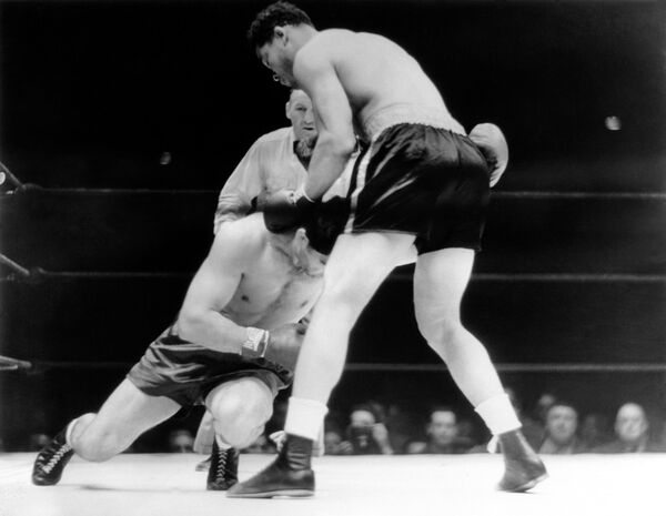 Max Schmeling, left, German challenger, sinking to the canvas to escape the relentless hail of blows from US heavyweight champion Joe Louis, right, that drove him to dismal failure in sensational fashion at the Yankee stadium in New York, United States on June 30, 1938. Max Schmeling, left, German challenger, sinking to the canvas to escape the relentless hail of blows from US heavyweight champion Joe Louis, right, that drove him to dismal failure in sensational fashion at the Yankee stadium in New York, United States on June 30, 1938. - Sputnik International