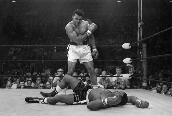 In this May 25, 1965 file photo, heavyweight champion Muhammad Ali stands over fallen challenger Sonny Liston, shouting and gesturing shortly after dropping Liston with a short hard right to the jaw, in Lewiston, Maine. The bout lasted only one minute into the first round. Ali is the only man ever to win the world heavyweight boxing championship three times. In this May 25, 1965 file photo, heavyweight champion Muhammad Ali stands over fallen challenger Sonny Liston, shouting and gesturing shortly after dropping Liston with a short hard right to the jaw, in Lewiston, Maine. The bout lasted only one minute into the first round. Ali is the only man ever to win the world heavyweight boxing championship three times. - Sputnik International
