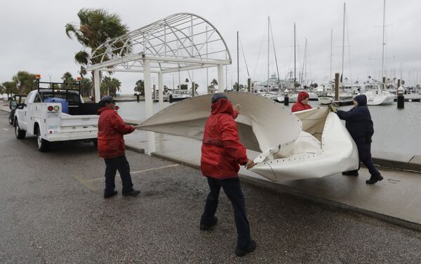 City workers pull down a canvas covering as the outer bands of Hurricane Harvey move closer, Friday, Aug. 25, 2017, in Corpus Christi, Texas - Sputnik International