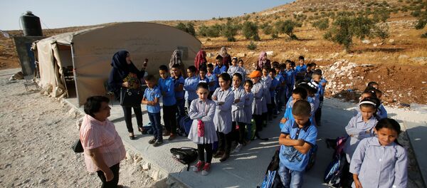 Palestinian schoolchildren queue outside a tent where they attend lessons after Israeli troops confiscated caravans used as school classrooms, due to the lack of an Israeli-issued construction permit, in the West Bank village of Jubbet Al Dhib, near Bethlehem August 24, 2017 Palestinian schoolchildren queue outside a tent where they attend lessons after Israeli troops confiscated caravans used as school classrooms, due to the lack of an Israeli-issued construction permit, in the West Bank village of Jubbet Al Dhib, near Bethlehem August 24, 2017 - Sputnik International