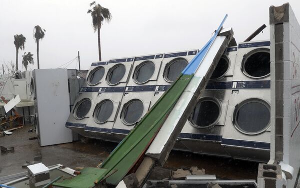 Clothes dryers are exposed to the elements after a laundromat lost its roof and portions of walls in the wake of Hurricane Harvey. - Sputnik International
