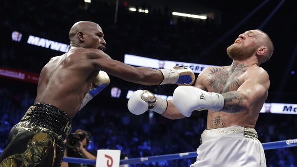 Floyd Mayweather Jr. hits Conor McGregor in a super welterweight boxing match Saturday, Aug. 26, 2017, in Las Vegas. - Sputnik International