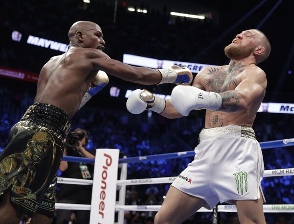 Floyd Mayweather Jr. hits Conor McGregor in a super welterweight boxing match Saturday, Aug. 26, 2017, in Las Vegas. - Sputnik International