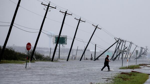 A man walks through floods waters and onto the main road after surveying his property which was hit by Hurricane Harvey in Rockport, Texas, U.S. August 26, 2017. - Sputnik International