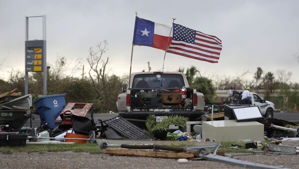 The Texas state flag and American flag wave in the wind over an area of debris left behind in the wake of Hurricane Harvey, Sunday, Aug. 27, 2017, in Rockport, Texas. - Sputnik International