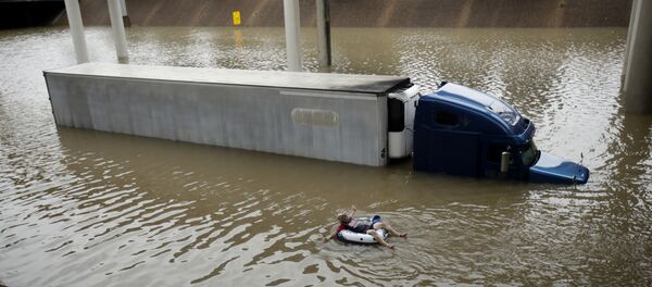 A man floats past a truck submerged on a freeway flooded by Tropical Storm Harvey on Sunday, Aug. 27, 2017, near downtown Houston. A man floats past a truck submerged on a freeway flooded by Tropical Storm Harvey on Sunday, Aug. 27, 2017, near downtown Houston. - Sputnik International