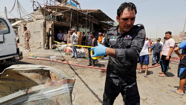 A member of Iraqi security forces put a warning tape at the site of a car bomb attack in Jamila market in Sadr City district of Baghdad, Iraq - Sputnik International