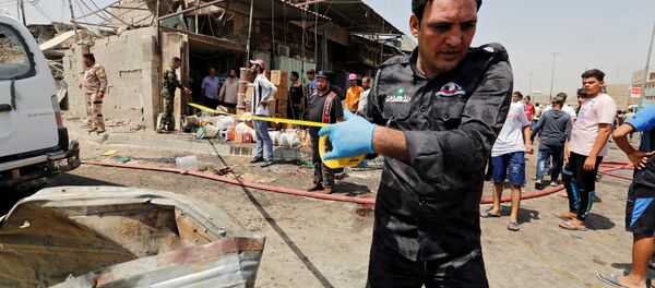 A member of Iraqi security forces put a warning tape at the site of a car bomb attack in Jamila market in Sadr City district of Baghdad, Iraq - Sputnik International