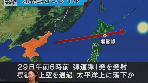 A woman walks past a large TV screen showing news about North Korea's missile launch in Tokyo, Japan, August 29, 2017. - Sputnik International