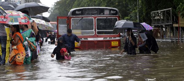 People walk through a waterlogged street following heavy rains in Mumbai, India - Sputnik International