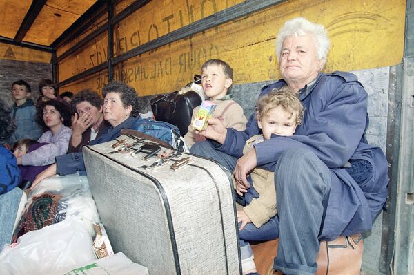 Bosnian refugees from Siroki Brijeg, on the frontline close to Mostar in Bosnia-Herzegovina, sit in a truck along with their belongings waiting to embark on a ferry to the island of Brace, in Split's harbor, Croatia on April 9, 1992. - Sputnik International