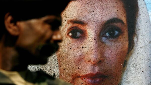 A portrait of Benazir Bhutto on the side of her open-air vehicle is splattered with bomb residue, as it is guarded by a Pakistani soldier in Karachi, Pakistan, on Friday Oct. 19, 2007, following an assassination attempt on Thursday. - Sputnik International