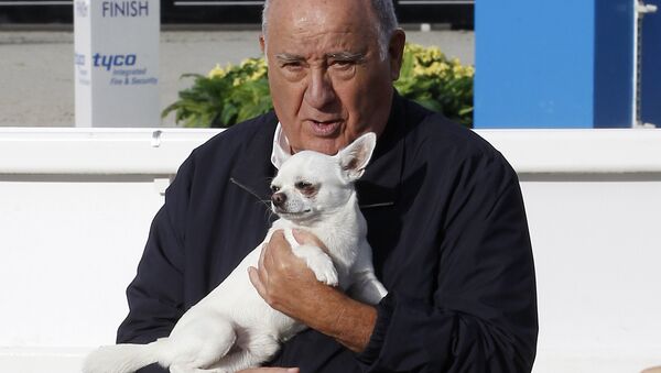 In this July 28, 2013 photo, Amancio Ortega Gaona, founding shareholder of Inditex fashion group, best known for its chain of Zara clothing and accessories retail shops, holds a dog during the Casas Novas International Jumping Show in Arteixo, A Coruña, in the Galicia region of northwest Spain. - Sputnik International