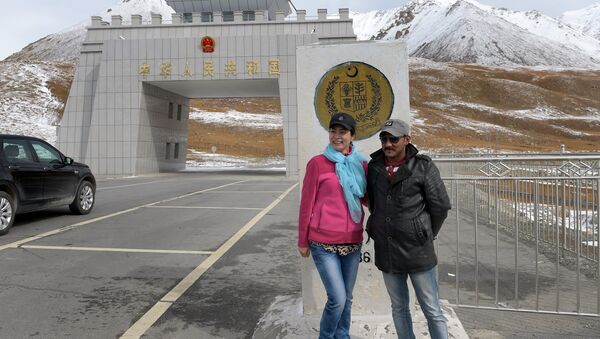In this photograph taken on September 29, 2015, a Chinese woman (L) poses for a photograph with a Pakistani man at the Pak-China Khunjerab Pass, the world's highest paved border crossing at 4,600 metres above sea level - Sputnik International