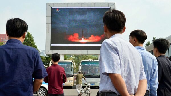 North Koreans watch a news report showing North Korea's Hwasong-12 intermediate-range ballistic missile launch on electronic screen at Pyongyang station in Pyongyang, North Korea, in this photo taken by Kyodo August 30, 2017 - Sputnik International