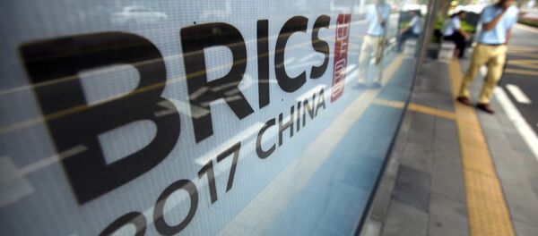 A man stands near a billboard advertising the 2017 BRICS Summit at a bus shelter in Xiamen in southeastern China's Fujian Province, Saturday, Sept. 2, 2017 A man stands near a billboard advertising the 2017 BRICS Summit at a bus shelter in Xiamen in southeastern China's Fujian Province, Saturday, Sept. 2, 2017 - Sputnik International