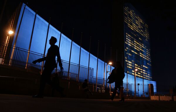 Pedestrians walk by United Nations Headquarters, lit up in blue light, a day in advance of the 70th Anniversary of the U.N., in New York City. File Photo. Pedestrians walk by United Nations Headquarters, lit up in blue light, a day in advance of the 70th Anniversary of the U.N., in New York City. File Photo. - Sputnik International