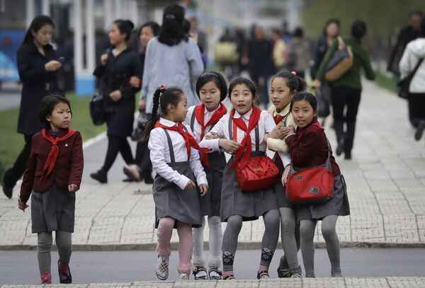 North Korean school girls react upon seeing their photograph being taken as they walk along Mirae Scientists Street in Pyongyang - Sputnik International