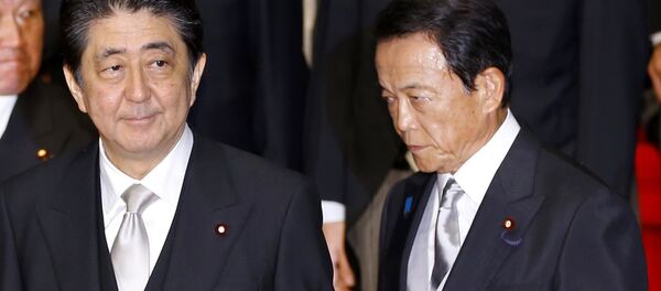 In this Aug. 3, 2017 photo, Japan's Prime Minister Shinzo Abe, left, and Deputy Prime Minister Taro Aso leave after an official photo session with Abe's new Cabinet at the prime minister's official residence in Tokyo - Sputnik International