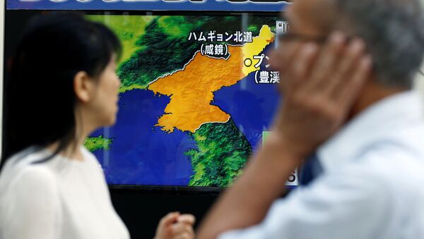 People walk past a street monitor showing a news report about North Korea's nuclear test, in Tokyo, Japan, September 3, 2017 - Sputnik International