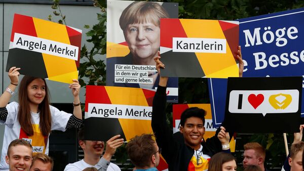 Supporters of German Chancellor Angela Merkel of the Christian Democratic Union party (CDU) hold banners before a TV debate with her challenger Germany's Social Democratic Party SPD candidate for chancellor Martin Schulz in Berlin, Germany, September 3, 2017. - Sputnik International