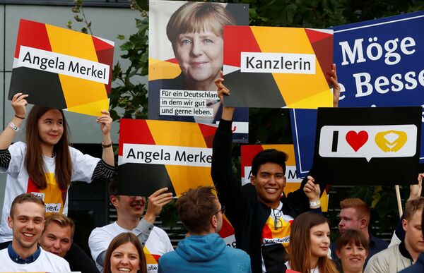 Supporters of German Chancellor Angela Merkel of the Christian Democratic Union party (CDU) hold banners before a TV debate with her challenger Germany's Social Democratic Party SPD candidate for chancellor Martin Schulz in Berlin, Germany, September 3, 2017. Supporters of German Chancellor Angela Merkel of the Christian Democratic Union party (CDU) hold banners before a TV debate with her challenger Germany's Social Democratic Party SPD candidate for chancellor Martin Schulz in Berlin, Germany, September 3, 2017. - Sputnik International