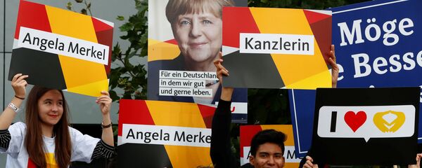 Supporters of German Chancellor Angela Merkel of the Christian Democratic Union party (CDU) hold banners before a TV debate with her challenger Germany's Social Democratic Party SPD candidate for chancellor Martin Schulz in Berlin, Germany, September 3, 2017. Supporters of German Chancellor Angela Merkel of the Christian Democratic Union party (CDU) hold banners before a TV debate with her challenger Germany's Social Democratic Party SPD candidate for chancellor Martin Schulz in Berlin, Germany, September 3, 2017. - Sputnik International