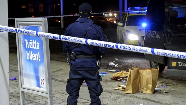 A police officer stands inside a roped off an area on a gas station in Fittja, Sweden, where a man was found severely injured in a minivan after being shot at when taking part in a pro-Kurdish demonstration Saturday, Feb. 13, 2016 - Sputnik International