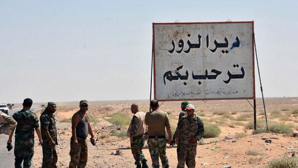 This photo released on Sunday, Sept 3, 2017 by the Syrian official news agency SANA, shows Syrian troops and pro-government gunmen standing next to a placard in Arabic which reads, Deir el-Zour welcomes you, in the eastern city of Deir el-Zour, Syria - Sputnik International