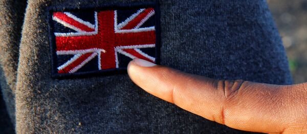 An Ethiopian migrant named Ermias (16 years old) points at an Union Jack patch as he waits on line during a food distribution near the former jungle in Calais, France, August 23, 2017 An Ethiopian migrant named Ermias (16 years old) points at an Union Jack patch as he waits on line during a food distribution near the former jungle in Calais, France, August 23, 2017 - Sputnik International