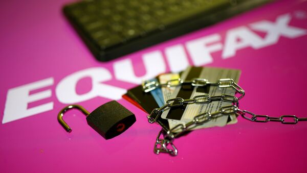 Credit cards, a chain and an open padlock is seen in front of displayed Equifax logo in this illustration taken September 8, 2017 - Sputnik International