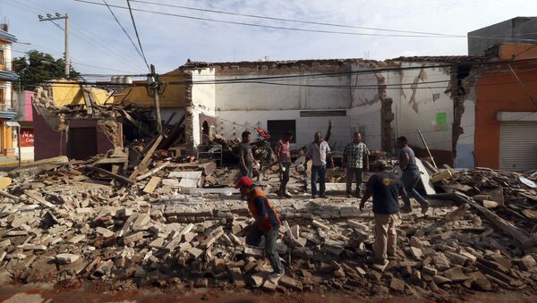 Residents stand on debris of a partially collapsed building felled by a massive earthquake in Juchitan, Oaxaca state, Mexico, Friday, Sept. 8, 2017. - Sputnik International
