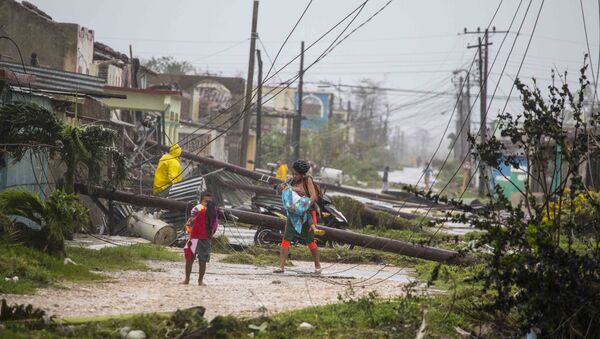 Residents walk near downed power lines felled by Hurricane Irma, in Caibarien, Cuba, Saturday, Sept. 9, 2017 - Sputnik International