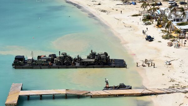 In this undated photo provided by the Ministry of Defence on Friday, Sept. 8, 2017, taken from a Royal Navy helicopter, a RLC Mexeflote approaches Sandy Bay Village beach, in Anguilla loaded with the 2 JCBs, 1 flatbed lorry, fork lift truck, BV 206 multi terrain vehicle, a Land Rover and a mobile generator. - Sputnik International
