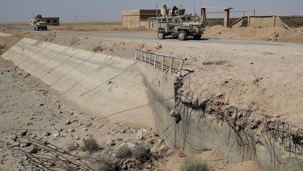 U.S. armored vehicles past near a destroyed bridge on a road that links to Raqqa city, northeast Syria. (File) - Sputnik International