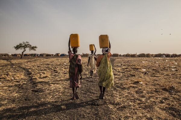 Three women carry water in a displaced persons camp in Melut, South Sudan. Three women carry water in a displaced persons camp in Melut, South Sudan. - Sputnik International