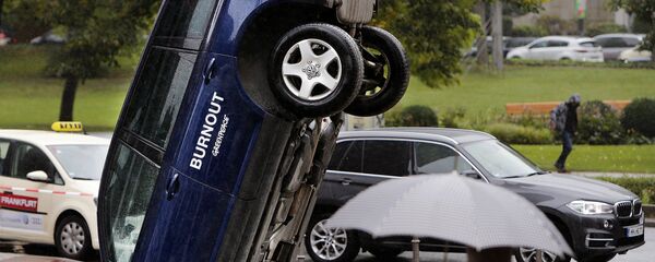 A Volkswagen Touareg stands upside down in front of the fair ground of the IAA Motor Show in Frankfurt, Germany, Wednesday, Sept. 13, 2017. The environmental organization Greenpeace installed the car the day before to protest against the car industry. From frighteningly fast hypercars to new electric SUVs, the Frankfurt auto show is a major event for car lovers wanting to get a glimpse of the future. - Sputnik International