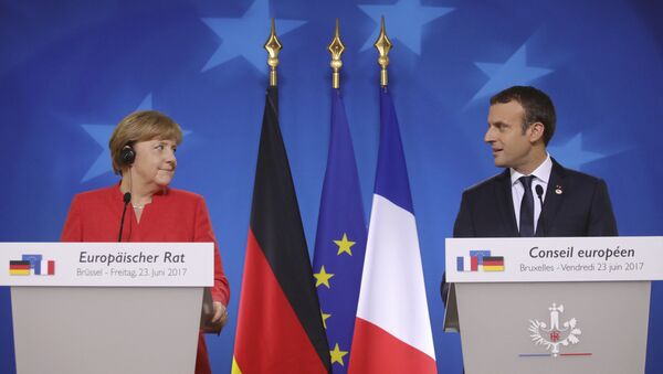 German Chancellor Angela Merkel, left, and French President Emmanuel Macron prepare to address the media at an EU summit in Brussels on Friday, June 23, 2017. - Sputnik International