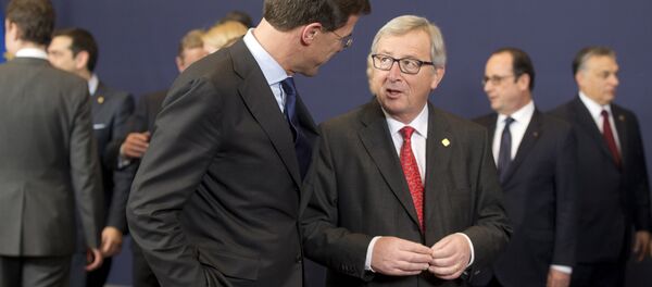 European Commission President Jean-Claude Juncker, center right, speaks with Dutch Prime Minister Mark Rutte during a group photo at an EU summit in Brussels on Thursday, Feb. 12, 2015. - Sputnik International
