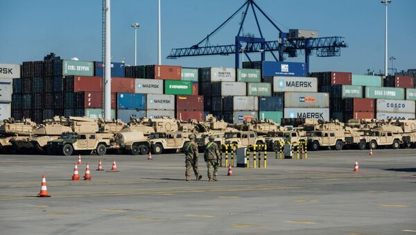 Soldiers walk near U.S. military equipment which arrived as part of NATO mission at port in Gdansk, Poland - Sputnik International