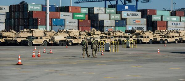Soldiers walk near U.S. military equipment which arrived as part of NATO mission at port in Gdansk, Poland - Sputnik International