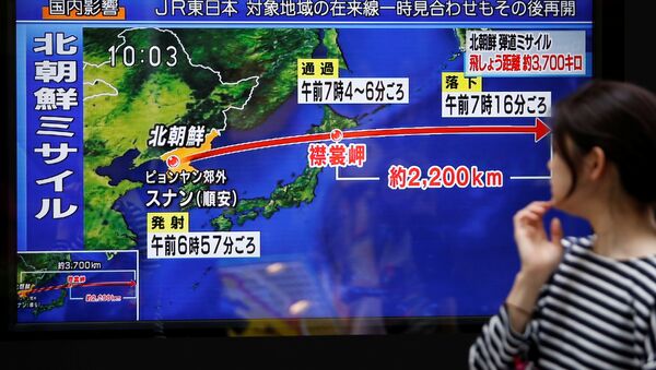A passerby looks at a TV screen reporting news about North Korea's missile launch in Tokyo, Japan September 15, 2017 - Sputnik International